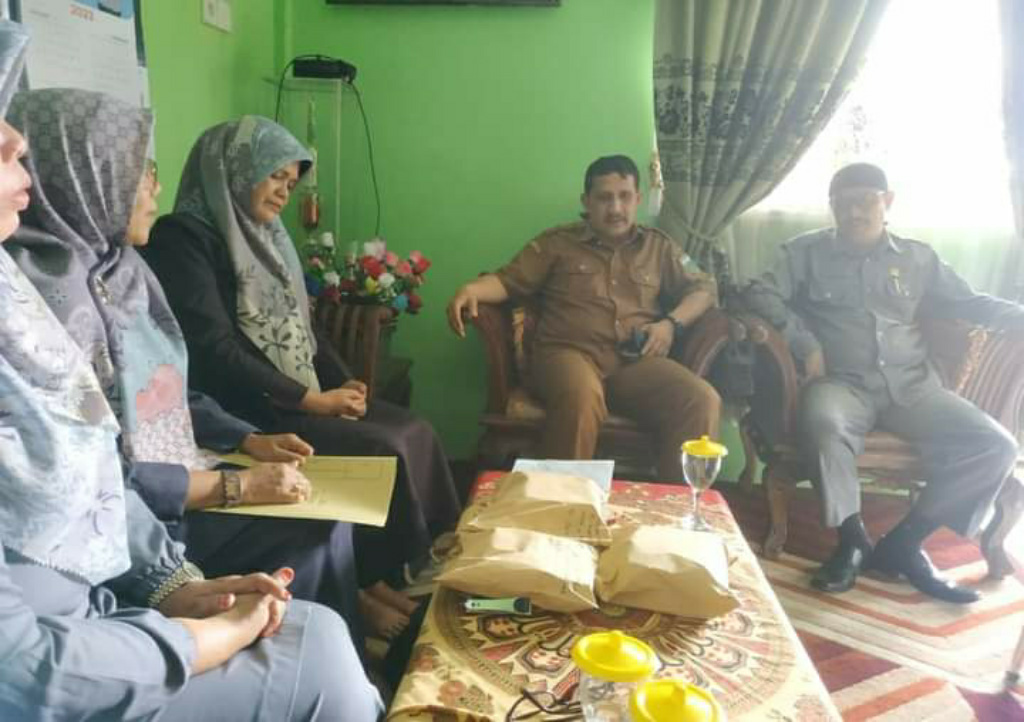 Kadis Diknas Padang Panjang, M Ali Tabrani dan Ketua K3S SD, Mukhlis, saat serahkan bantuan pada orang tua siswa penderita penyakit kanker, Selasa (24/01/2023) kemaren. (Asril)